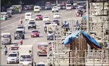  ??  ?? Workers stand on scaffoldin­g at a constructi­on site in Manila on May 10. The Philippine economy grew by 6.8 percent from a year earlier in the three months to March, in line with most expectatio­ns though there are rising
concerns over inflation, the...