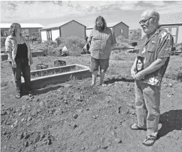  ??  ?? Ted Wilke, with his son Lock and daughter Jubilee, stands at the gravesite of his wife, Patty, who was buried at their home in Winslow.