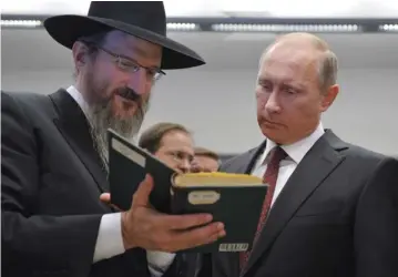  ??  ?? PRESIDENT VLADIMIR PUTIN talks with Russia’s Chief Rabbi Berel Lazar as he visits the Jewish Museum and Tolerance Center in Moscow last summer.