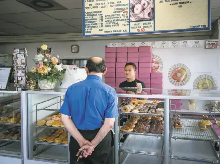  ?? John Storey / Special to The Chronicle ?? Danit Lean, son of the owners of A's Donuts near the decimated Coffey Park neighborho­od of Santa Rosa, waits on a customer.