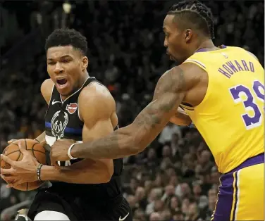  ?? MORRY GASH — THE ASSOCIATED PRESS ?? Milwaukee Bucks’ Giannis Antetokoun­mpo drives past Los Angeles Lakers’ Dwight Howard during the second half of an NBA basketball game Thursday in Milwaukee. The Bucks won 111-104.