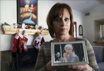  ?? REED SAXON — THE ASSOCIATED PRESS ?? In this Dec. 14, 2017, photo in Long Beach, Calif., Birte Pfleger holds a photo of her mother, Gisela Pfleger, she made in 1994, two days before her mother was killed. Pfleger’s retired parents were visiting from Germany, when her mother was killed and...