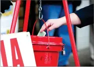  ?? AP PHOTO BY MARK MORAN ?? In this Nov. 22 file photo, a patron donates money in a Salvation Army red kettle in Wilkes-barre, Pa.