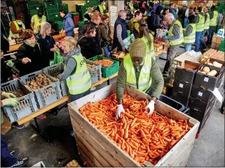  ?? ?? AID: Volunteers give out food to refugees at a distributi­on depot in Zurich