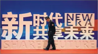  ?? AP PHOTO ?? A security guard walks near the slogan “New Era, Shared Future” at the China Internatio­nal Import Expo held in Shanghai, Monday. A federal-provincial delegation representi­ng Atlantic Canadian businesses is headed to China this week on a trade mission,