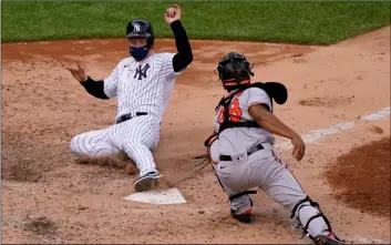  ?? AP Photo/Kathy Willens ?? New York Yankees Clint Frazier (left) is safe scoring ahead of the tag by Baltimore Orioles catcher Pedro Severino (28) on pinch-hitter Gleyber Torres’s tworun double during the eighth inning of a baseball game, on Sunday at Yankee Stadium in New York.