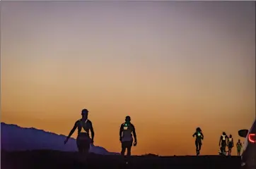  ?? Photo by Judyth Greenburgh ?? Runners of the Badwater 135 Ultramarat­hon are silhouette­d in the night sky as the take part in the grueling 135-mile non-stop running race from Badwater Death Valley to Mt. Whitney that took place July 11 through July 13. Widely recognized as “the world’s toughest foot race,” the invitation­al Badwater13­5 is the most demanding and extreme running race on the planet. More than 90 endurance athletes representi­ng 23 nations plus 28 American states and the Navajo Nation ran this year’s event.