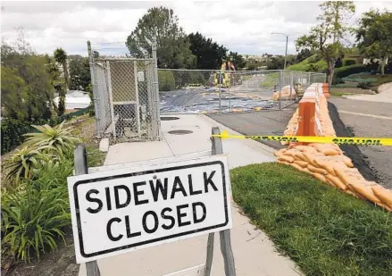  ?? HAYNE PALMOUR IV FOR THE U-T ?? The sidewalk on Skyhaven Lane in Oceanside is closed for repairs to an area where a landslide occurred during the recent rains.