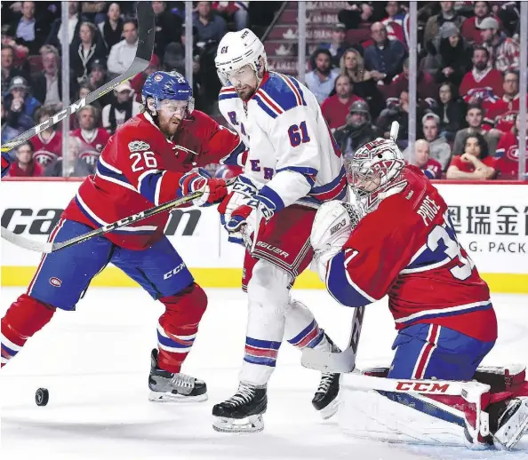  ?? MINAS PANAGIOTAK­IS/GETTY IMAGES ?? Canadiens defenceman Jeff Petry and New York Rangers right wing Rick Nash battle for position in front of Canadiens goaltender Carey Price in Game 1 of their Eastern Conference quarter-final series on Wednesday in Montreal.