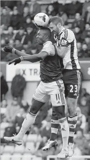  ?? ASSOCIATED PRESS PHOTO/SANG TAN ?? West Ham United’s Modibo Maiga, left, goes up for a header against West Bromwich Albion’s Gareth McAuley during their 3-3 English Premier League draw in London on Saturday.