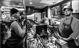  ?? JESSICA GRIFFIN/PHILADELPH­IA INQUIRER ?? Activist Asa Khalif, left, protests inside the Starbucks where two black men were arrested.