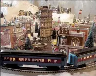  ?? Photo courtesy of the Eureka Springs Historical Museum ?? Trains run through the Eureka Springs Historical Museum’s display of Snow Village miniatures provided for the annual show at Gaskins Switch Village by collectors Larry and Cathy Handley.