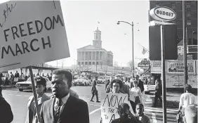  ?? PHOTO BY FRANK EMPSON / THE TENNESSEAN ?? Anti-segregatio­n demonstrat­ors march in the vicinity of the downtown area on March 23, 1963, to protest racial discrimina­tion in Nashville. In the foreground left, with the “Freedom March” sign, is John Lewis, chairman of the Student Central Committee of the Nashville Christian Leadership Council, sponsors of the movement.