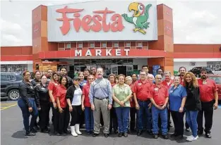  ?? Dave Rossman ?? CEO Michael Byars is with a store team at the Fiesta Mart at 12355 Main.