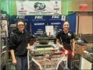  ??  ?? Shenendeho­wa High School students Isabel Rodrigues, left, and Sydney Walker show off their team’s robot during the first day of competitio­n Friday in the New York Tech Valley Regional FIRST Robotics Competitio­n in the East Campus Village Arena at...