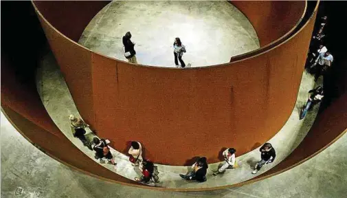  ?? Foto: Reuters ?? Besucher gehen durch eine massive Stahlskulp­tur des amerikanis­chen Künstlers Richard Serra während einer Sondervors­tellung im Guggenheim-Museum in Bilbao, Nordspanie­n, im Jahr 2005. Die Installati­on „The Matter of Time“basiert auf Serras Theorien der „Torqued ellipses“.