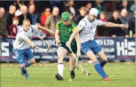  ??  ?? Scotland’s Kevin Bartlett, left, and Shaun Nicolson deal with Damien Healy, Ireland, during the recent shinty/hurling internatio­nal at the Bught Park, Inverness.