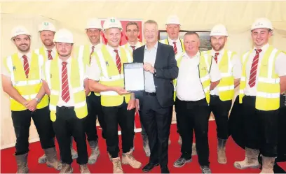  ??  ?? ●●NHBC north west regional director Ian Davies presenting the award to Redrow project manager Ashley Terron and members of his constructi­on team