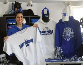  ?? MARSHALL GORBY / STAFF ?? Deanna Bonilla, manager of the Fan Store, 205 N. Main St., Springboro, holds up a Lady Panther basketball T-shirt on Wednesday. The Springboro Lady Panthers will play Pickeringt­on Central at 8 p.m. today in the Division I state semifinal at UD Arena in Dayton.