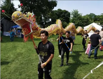  ?? Photos by Joseph B. Nadeau/The Call ?? Top photo, The Generation­s Barbershop Quartet performs Sunday; middle photo, the Bryant University Chinese dragon performanc­e team wows the crowd with a traditiona­l exhibition during a recreation of the 1904 World’s Fair; at right, Daryl ‘Black Eagle’...