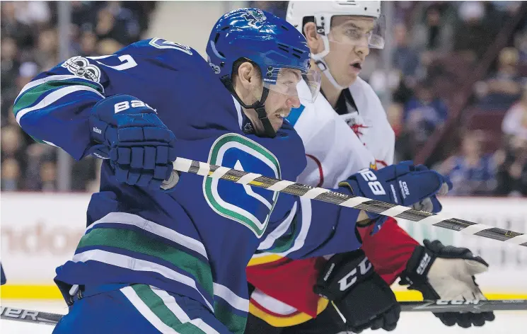  ?? GERRY KAHRMANN/PNG FILES ?? Vancouver Canucks’ Anton Rodin and Calgary Flames’ Sean Monahan jostle during an NHL game at Rogers Arena last January.