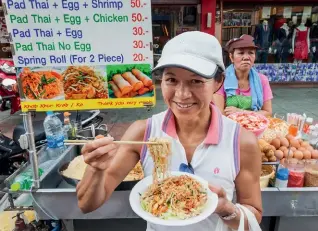  ??  ?? From left: A pad thai stall in Bangkok; crispy catfish salad served with green oak, shredded green mango, red onion, cabbage, chilli, peanuts, and spicy sauce.