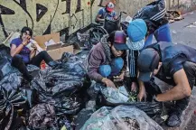  ??  ?? Families scavenging for food in Caracas. María Carolina Merchán, above right, weighs 30 kilos. Her son, Kenyerber, died of starvation.