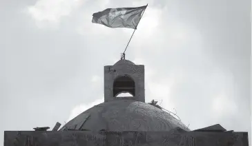  ?? JOSE A. IGLESIAS Miami Herald ?? The flag flies atop the Catholic Church in Haiti, rebuilt after it was destroyed in the 2010 earthquake.