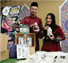  ??  ?? Suhaili dan suami menunjukka­n produk kecantikan penjagaan diri yang mendapat permintaan tinggi daripada pelanggan.