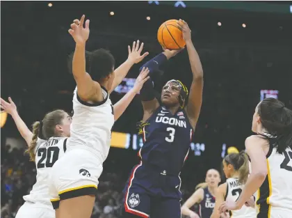 ?? MORRY GASH/ THE ASSOCIATED PRESS ?? UConn forward Aaliyah Edwards shoots over Iowa players during their Final Four game in the women's NCAA Tournament earlier this month in Cleveland. After finishing her college career, Edwards is projected to be a first-round pick in Monday's WNBA draft.