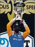  ?? DARRON CUMMINGS – AP ?? Scott Dixon raises the trophy after winning Saturday’s Indycar Series race at Indianapol­is Motor Speedway.