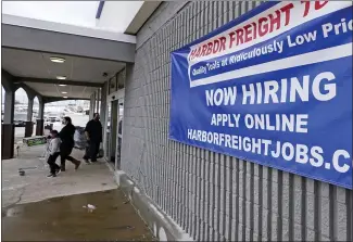  ?? THE ASSOCIATED PRESS ?? A “Now Hiring” sign hangs on the front wall of a Harbor Freight Tools store, in Manchester, N.H. The job market remains under stress as a resurgent coronaviru­s continues to batter the economy.