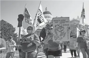  ?? RICH PEDRONCELL­I/AP FILE ?? Fast food workers and their supporters march past the California state Capitol in Sacramento calling for the passage of a bill to provide increased power to fast food workers on Aug. 16.