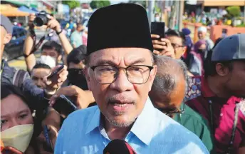  ?? AP ?? Malaysian opposition leader Anwar Ibrahim answers journalist­s’ questions after casting his vote at a polling station in Seberang Perai, Penang state, Malaysia, yesterday.