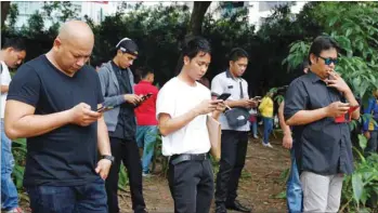  ??  ?? Filipinos use their mobile phones at a park in Taguig, Metro Manila. Paying some of Asia’s highest telecom charges while suffering slow Internet and frequent dropped calls, Filipinos will expect better service once the government picks a new entrant to break a duopoly in a market worth $5.1bn annually.