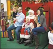  ?? Gina Ferazzi Los Angeles Times ?? THE McCLUSKEY family sits with Santa Claus at the Chico Mall. “Holiday spirit is hard to come by this year,” said a mother affected by the Camp fire.