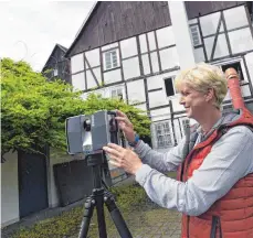  ?? FOTOS: CAROLINE SEIDEL ?? Auch die Außenhülle lässt sich abbilden: Birgit Kostner von der Firma Drücker&Schnitger Gbr scannt die Fassade eines älteren Fachwerkha­uses.