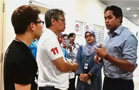  ??  ?? Hoping for the best: Khairy speaking to Loo (white shirt) and Ang’s brother, Arthur (left) outside the Sungai Buloh Hospital intensive care unit.