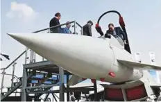  ?? Virendra Saklani/Gulf News ?? Visitors getting a feel of a Eurofighte­r Typhoon, one of the best fighter jets, that is on display at the event.