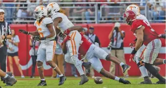  ?? AP PHOTO/VASHA HUNT ?? Alabama linebacker Chris Braswell strip-sacks Tennessee quarterbac­k Joe Milton III, causing a fumble that Alabama recovered and scored on during the second half of Saturday’s game in Tuscaloosa.