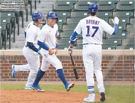  ??  ?? Ian Happ (left) is greeted by Nico Hoerner and Kris Bryant after hitting a two-run home run in the third inning Friday.