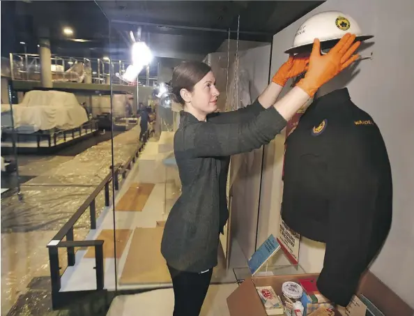  ?? ED KAISER ?? Conservato­r Susan Green installs items in a nuclear-readiness exhibit in the human history gallery at the new Royal Alberta Museum.