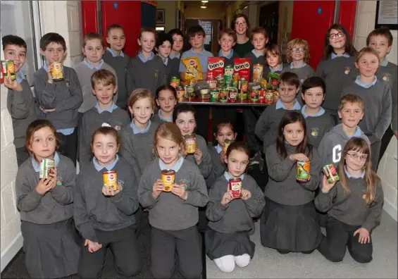  ??  ?? Teacher Laura Connick and her 3rd Class pupils at Scoil Mhuire in Rosslare Strand with some of the dog food they are donating to the WSPCA.