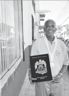  ??  ?? Guyana’s Claude Blackmore proudly displays the medal and diploma he received from Peru for his contributi­on to sport specifical­ly athletics over the years.