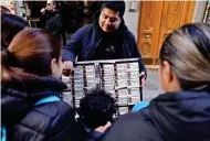  ?? ?? A PERSON BUYS Christmas lottery tickets to a street vendor outside the popular lottery outlet 'Dona Manolita' on Dec. 18, 2023 in central Madrid. (AFP)