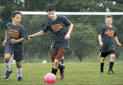  ?? Steph Chambers/Post-Gazette ?? Luke Ball, 13, center, dribbles a soccer ball upfield during a youth soccer camp Friday in Pine. Luke was the recipient of a new heart through Donate Life PA when he was 7, and is being featured in a statewide campaign that kicked off in May called...