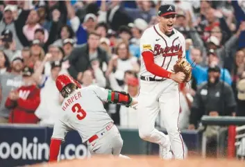  ?? AP PHOTO/JOHN BAZEMORE ?? Atlanta Braves first baseman Matt Olson (28) reacts to getting the final out by forcing out Philadelph­ia Phillies' Bryce Harper (3) on a fly ball, ending Monday's game in Atlanta.