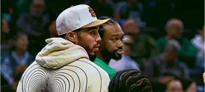  ?? JIM DAVIS/GLOBE STAFF ?? Jayson Tatum joined his teammates Sunday night, but he watched the game in street clothes.