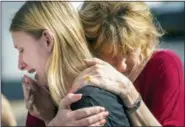  ?? STUART VILLANUEVA — THE GALVESTON COUNTY DAILY NEWS VIA AP ?? Santa Fe High School student Dakota Shrader is comforted by her mother Susan Davidson following a shooting at the school on Friday in Santa Fe, Texas. Shrader said her friend was shot in the incident.