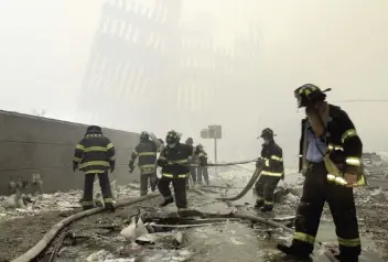  ?? MARK LENNIHAN AP ?? On Sept. 11, 2001, near the skeleton of the World Trade Center, New York City firefighte­rs work amid debris. The Taliban rulers of Afghanista­n had sheltered the al-Qaida terror network, which conducted the attacks.